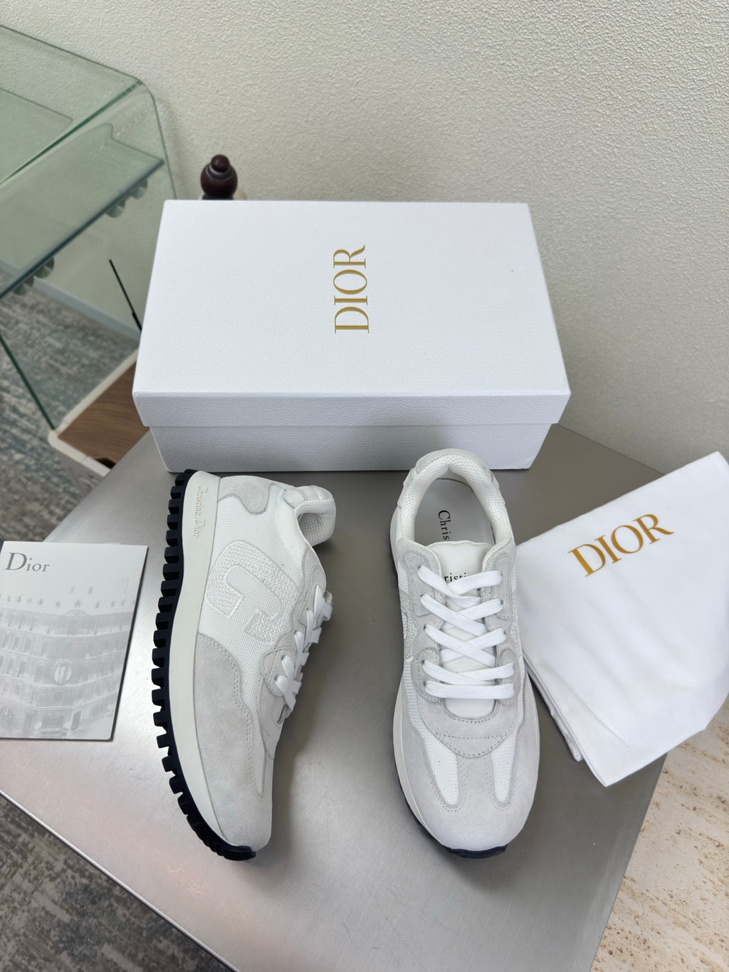 White lace-up sneakers with dark gripped sole and subtle textured overlays