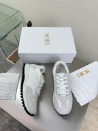 White lace-up sneakers with dark gripped sole and subtle textured overlays