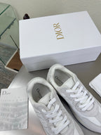Pair of white Dior lace-up sneakers with textured panels and rubber sole