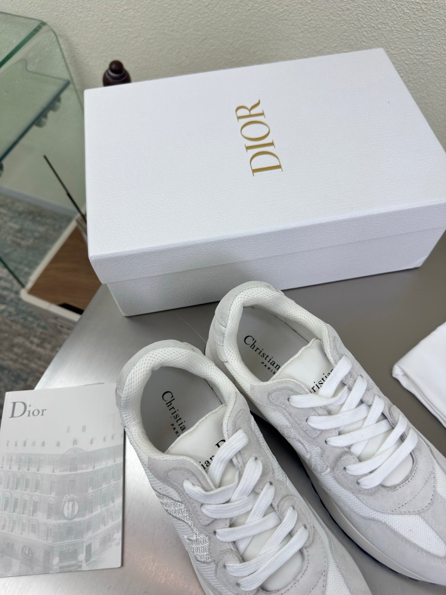 Pair of white Dior lace-up sneakers with textured panels and rubber sole