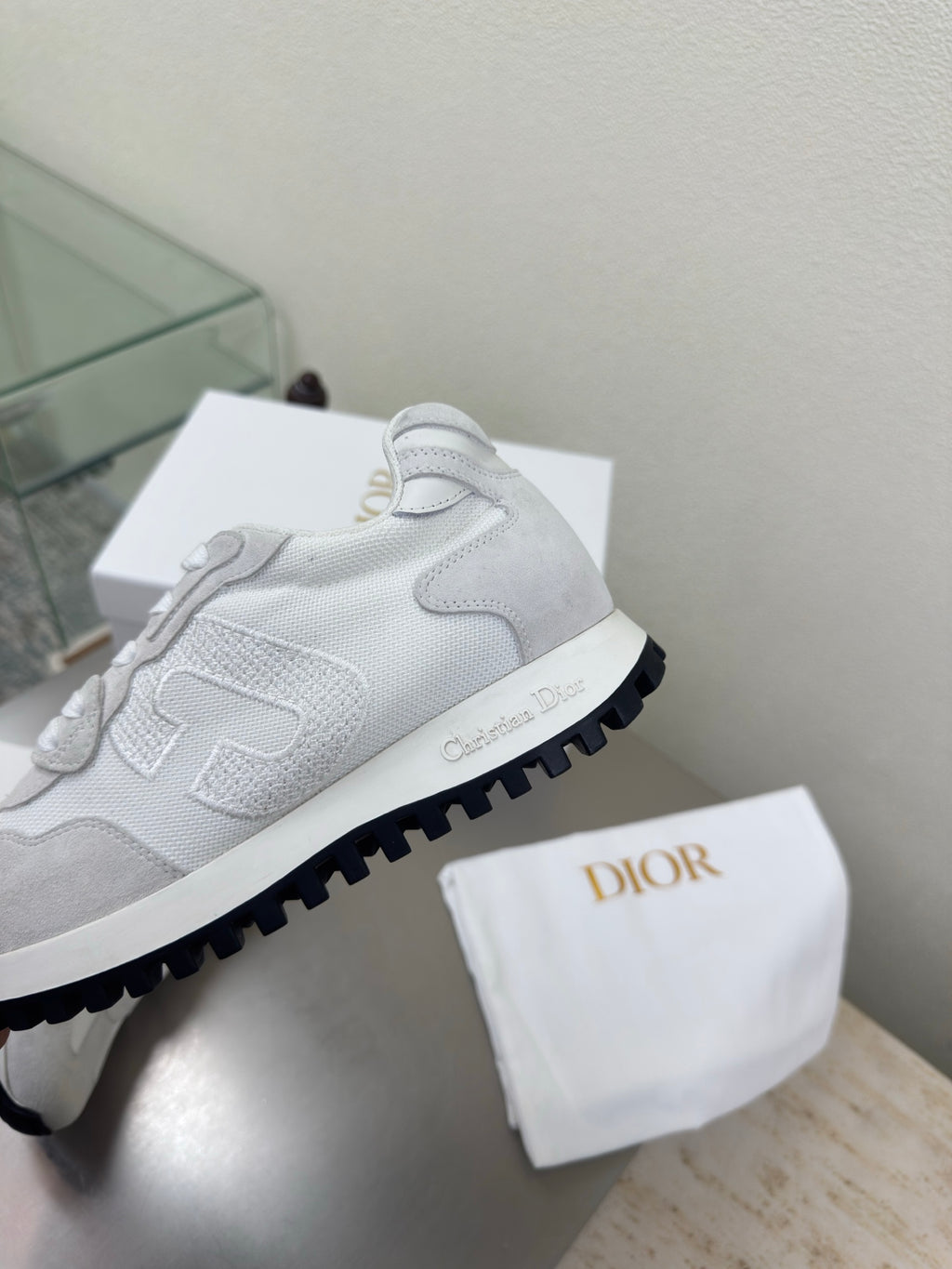 Close-up of light gray lace-up sneaker with chunky outsole and logo trim