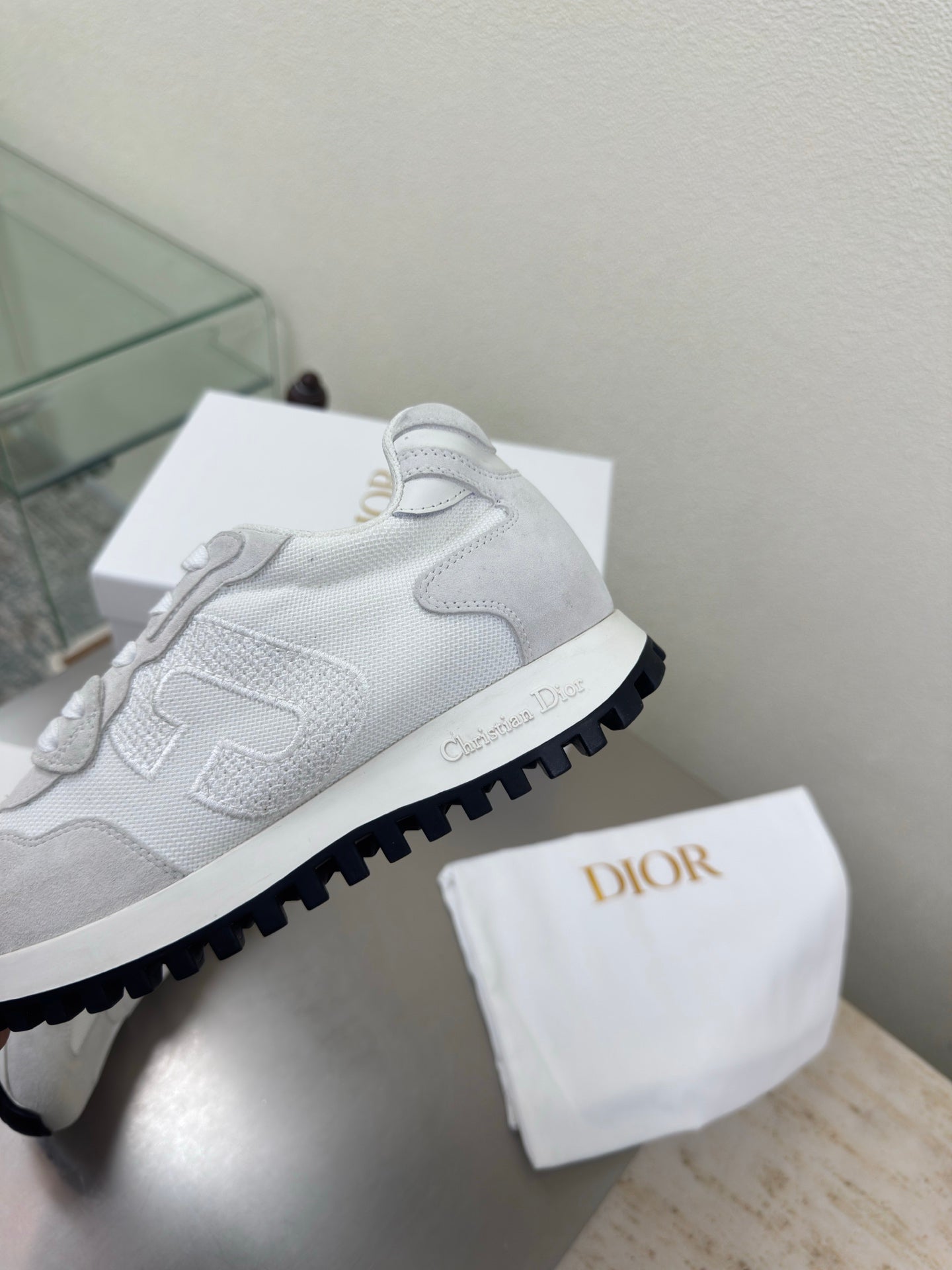 Close-up of light gray lace-up sneaker with chunky outsole and logo trim