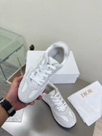 White lace-up sneakers on a box, with smooth upper and padded collar