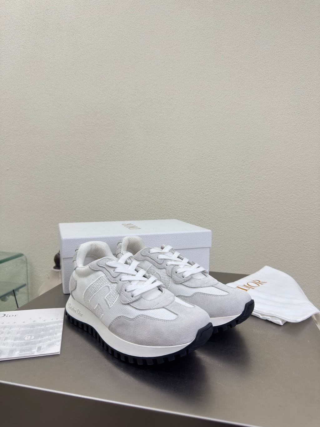 White and gray lace-up sneakers with chunky rubber sole and logo patch