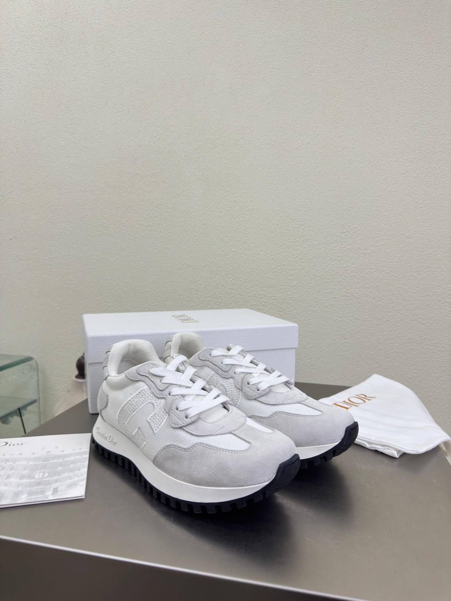 White and gray lace-up sneakers with chunky rubber sole and logo patch
