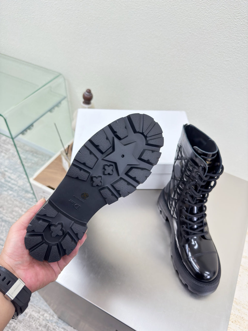 Black combat boot outsole and lace-up upper with lug tread pattern