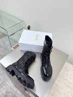 Pair of black glossy lace-up boots with rugged tread soles