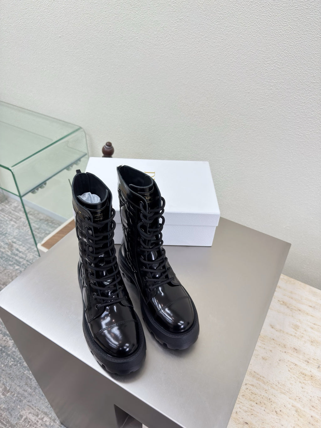 Black lace-up combat boots with glossy finish and thick tread sole