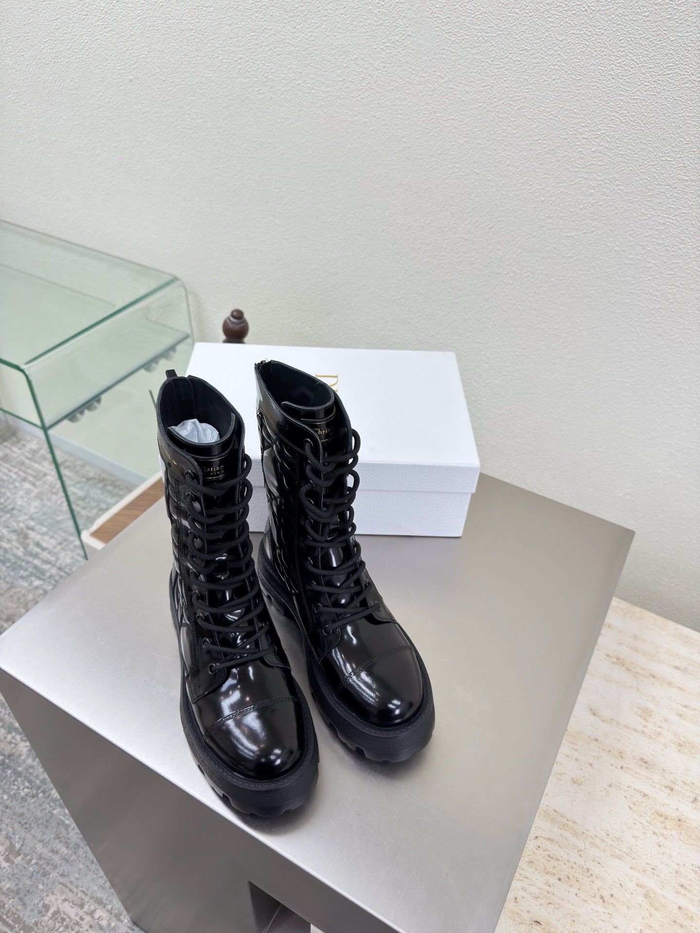 Black lace-up combat boots with glossy finish and thick tread sole