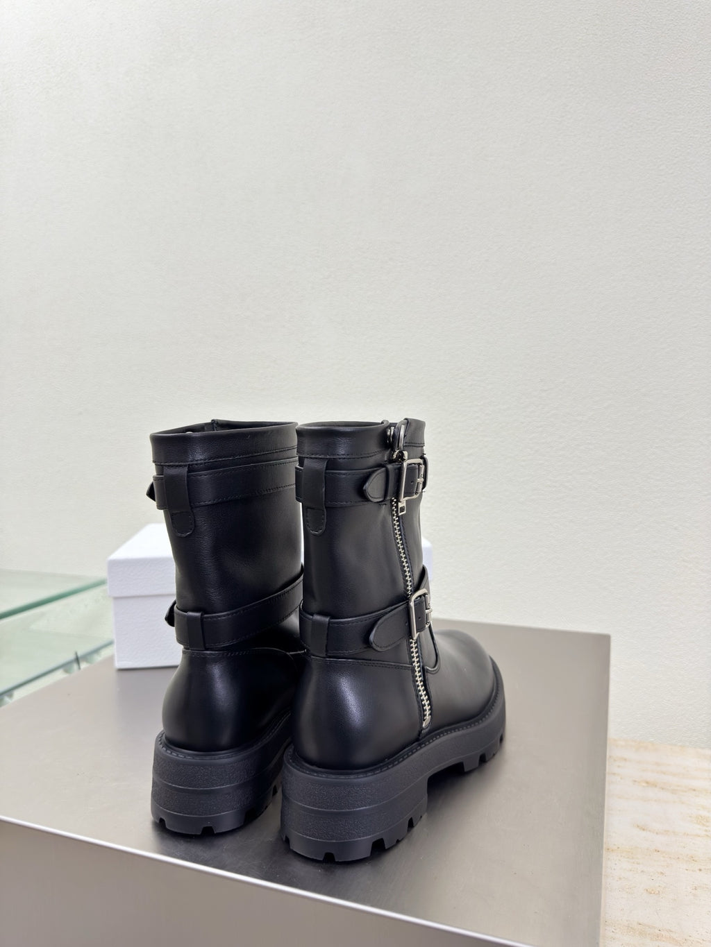 Black mid-calf boots with side buckles and decorative zipper detail