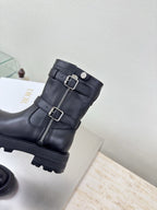 Black mid-calf boots with buckle straps and center zipper detail