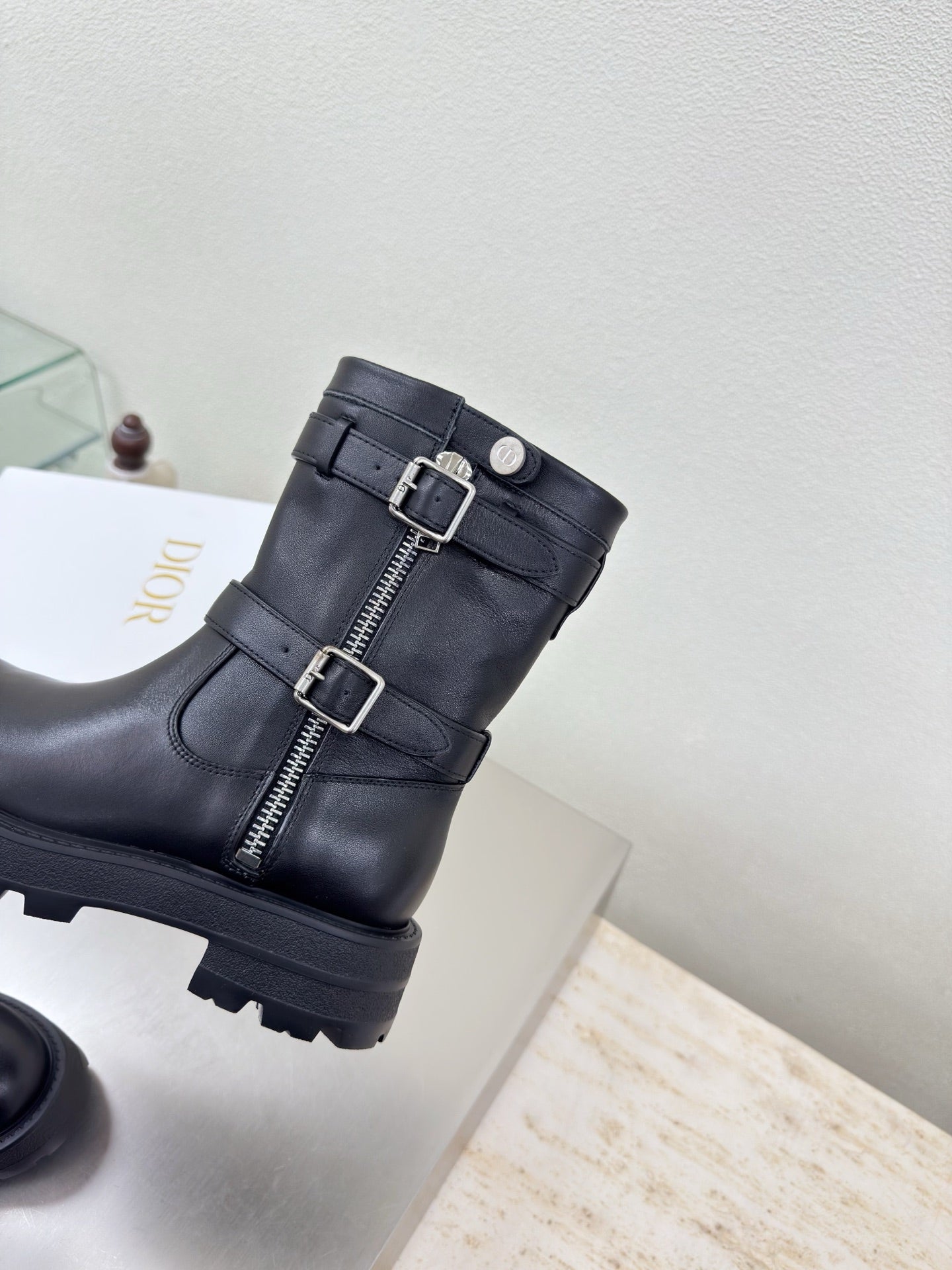 Black mid-calf boots with buckle straps and center zipper detail
