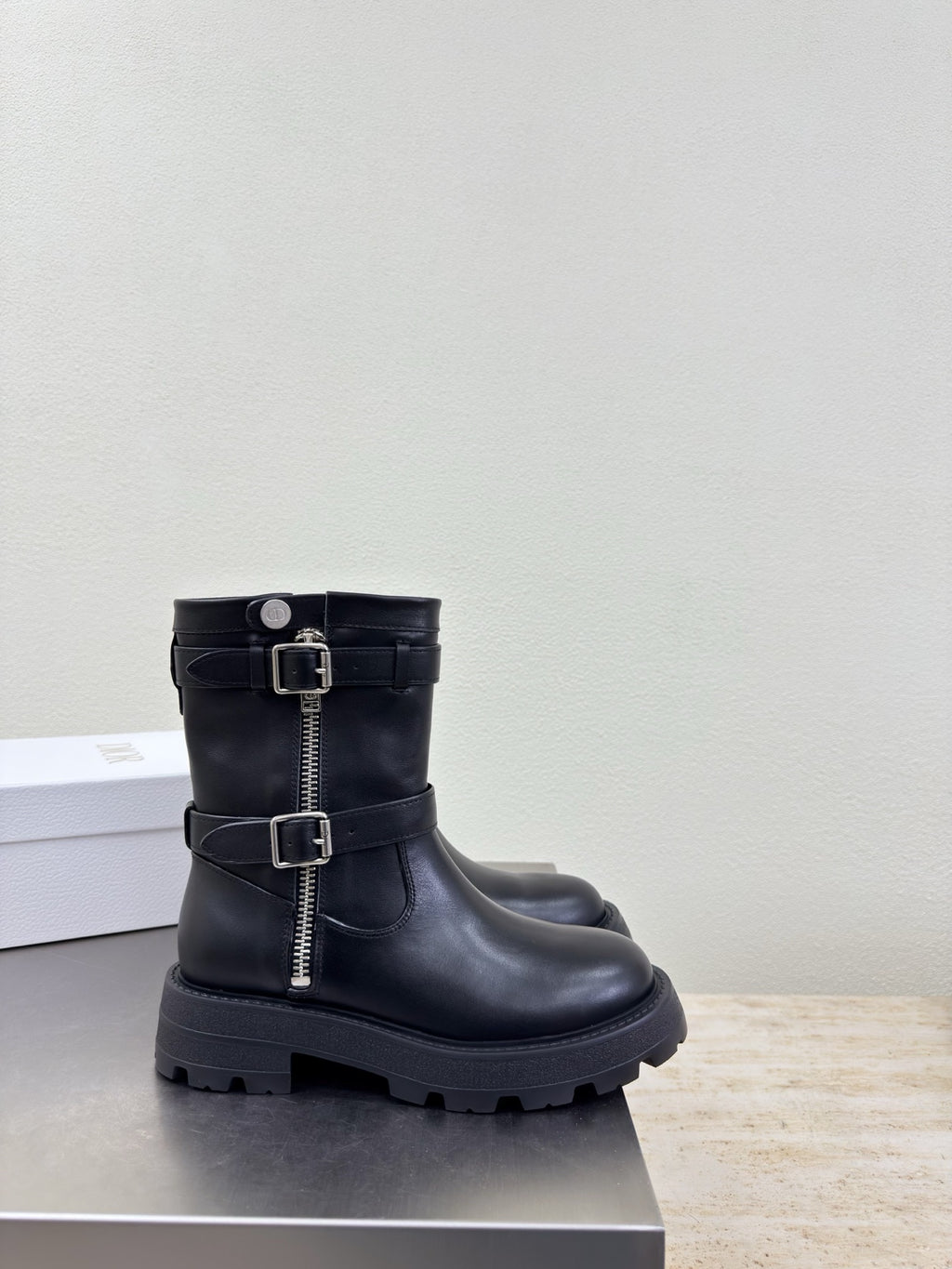 Black mid-calf boots with double buckle straps and thick treaded sole