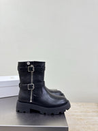 Black mid-calf boots with double buckle straps and thick treaded sole