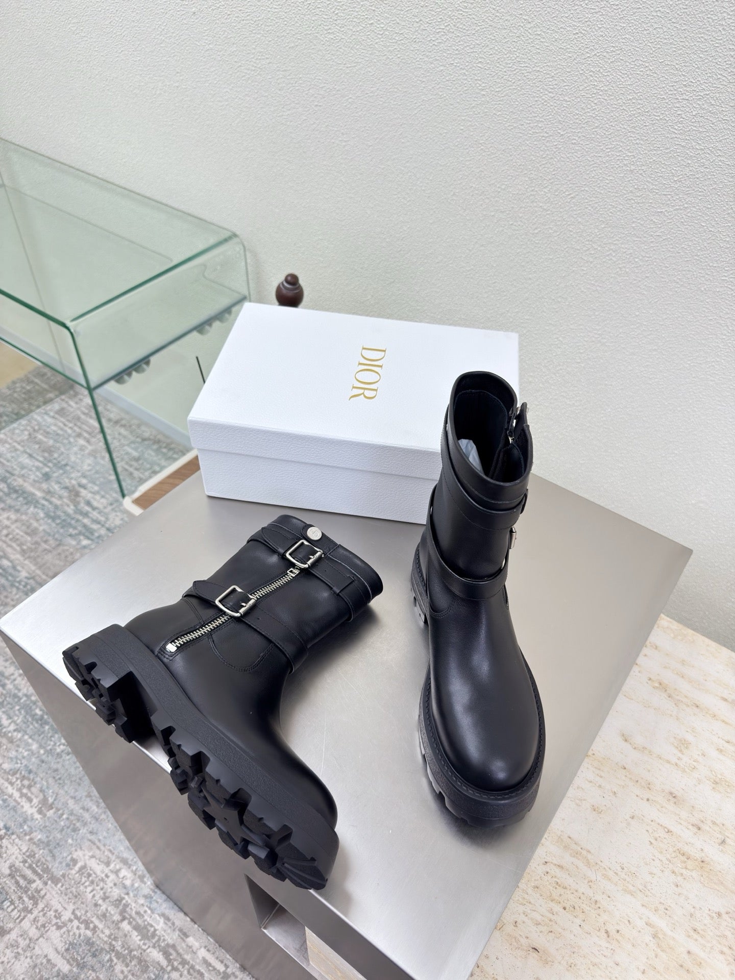 Pair of black mid-calf boots with buckles and chunky treaded outsole