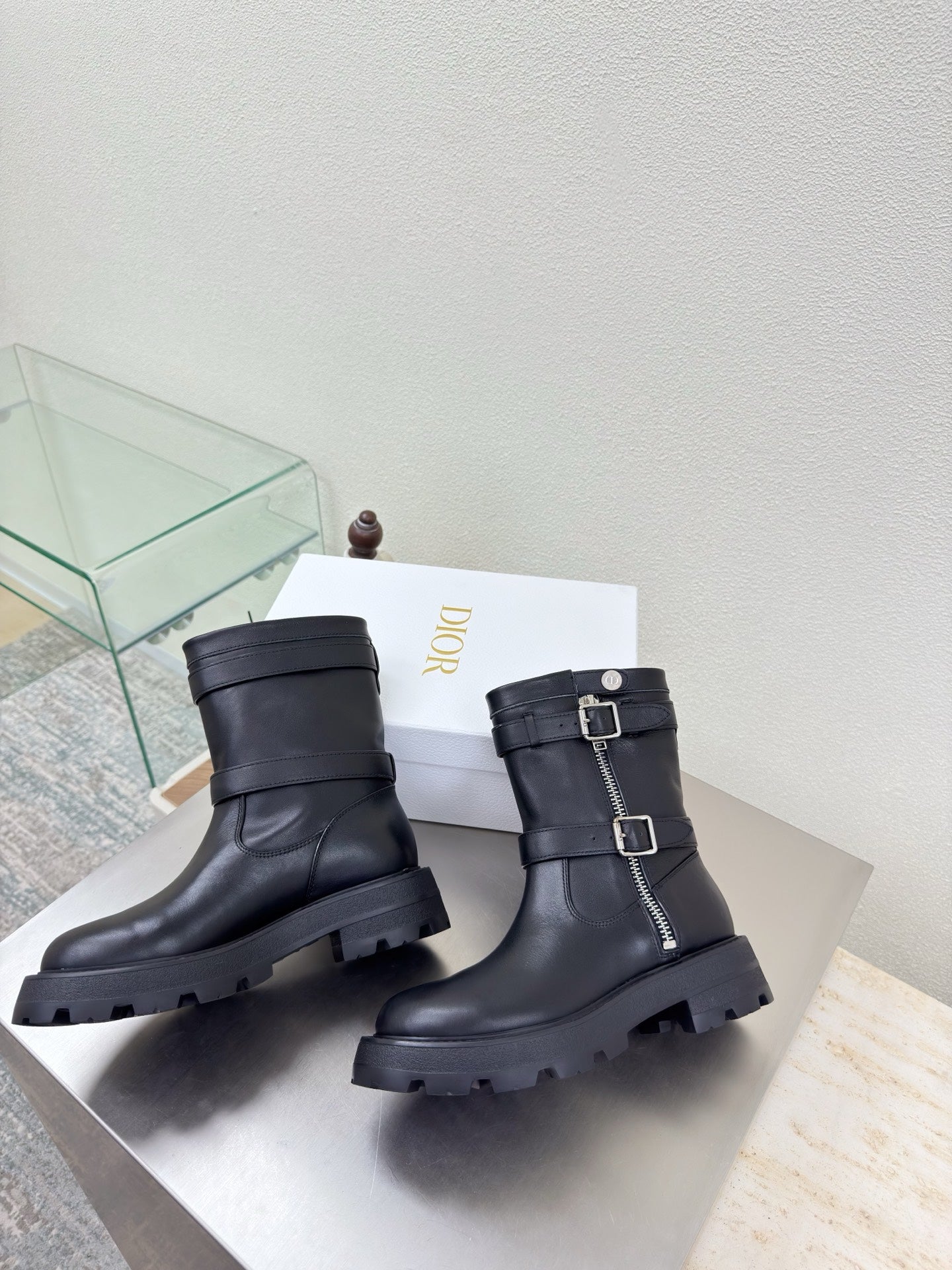Black mid-calf boots with buckled straps and thick lugged outsole