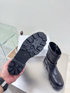 Boots showing black treaded outsole on the bottom and side zipper closure
