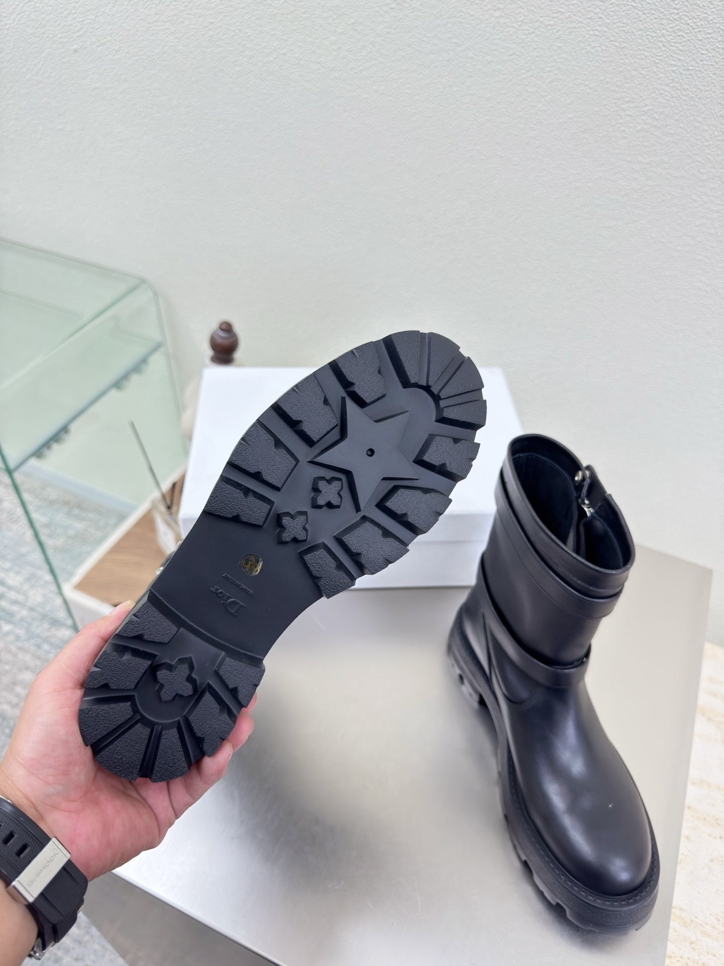 Boots showing black treaded outsole on the bottom and side zipper closure