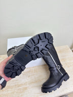 Black knee-high boot showing treaded outsole and side zipper details