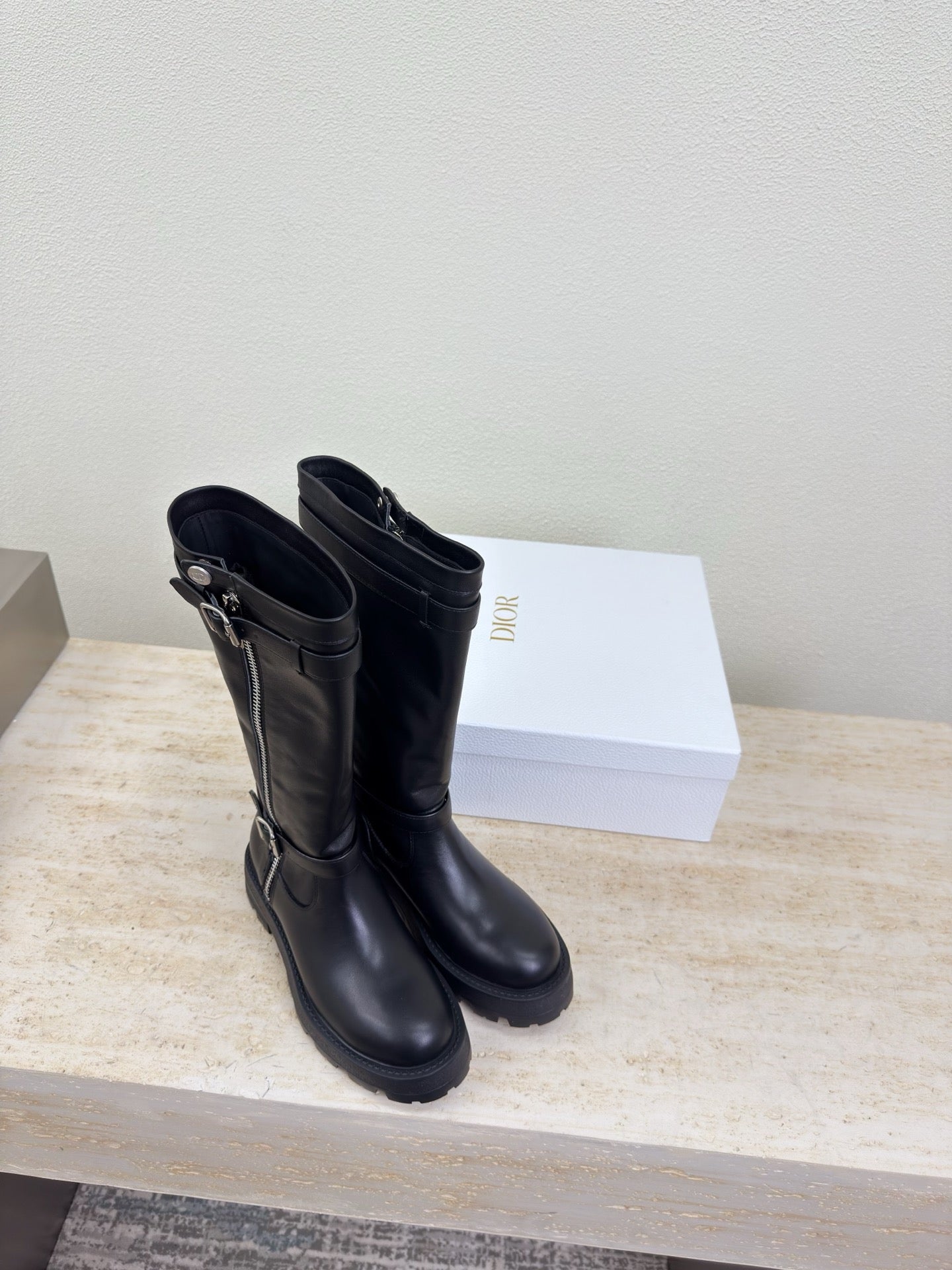 Knee-high black boots with side zippers and chunky lug soles, pair view