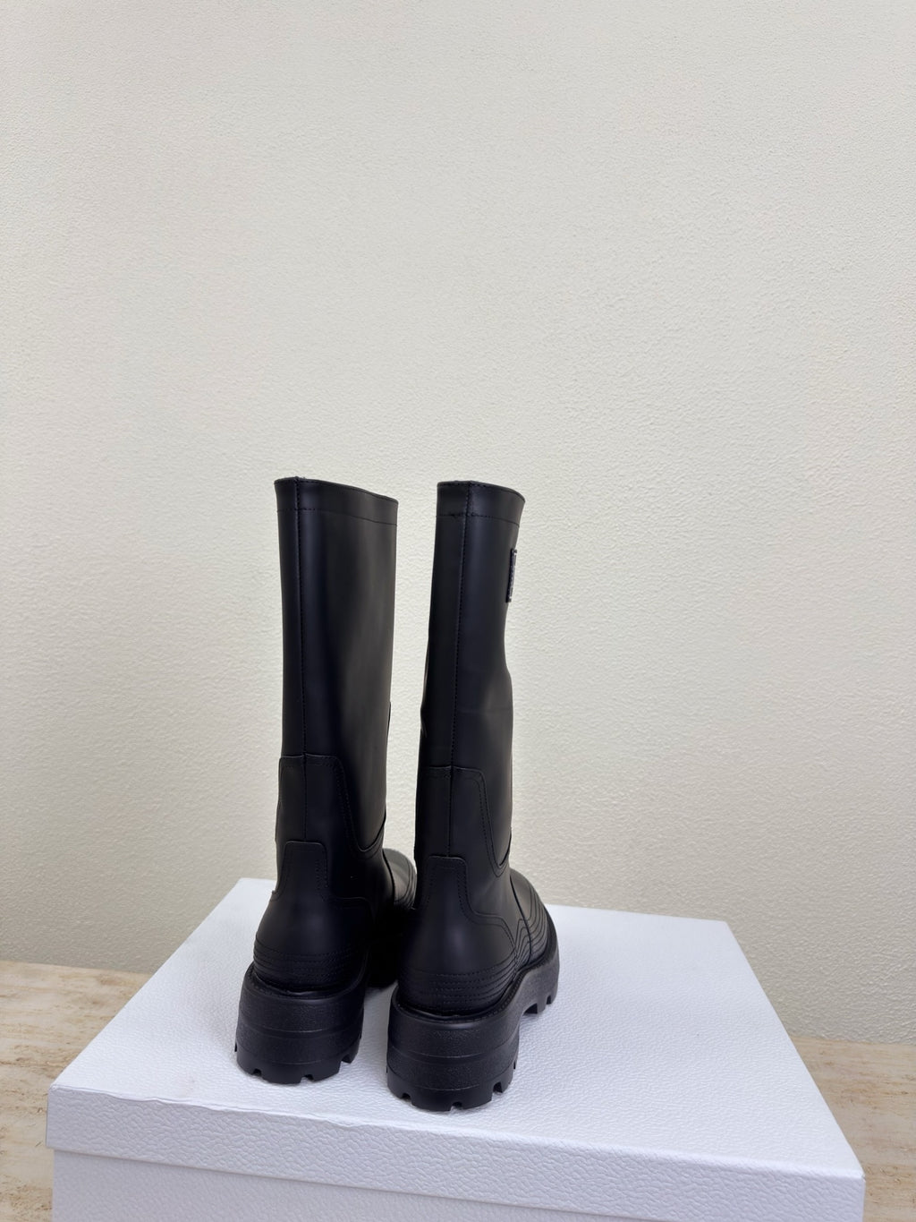 Women's dark knee-high boots, back view on display box