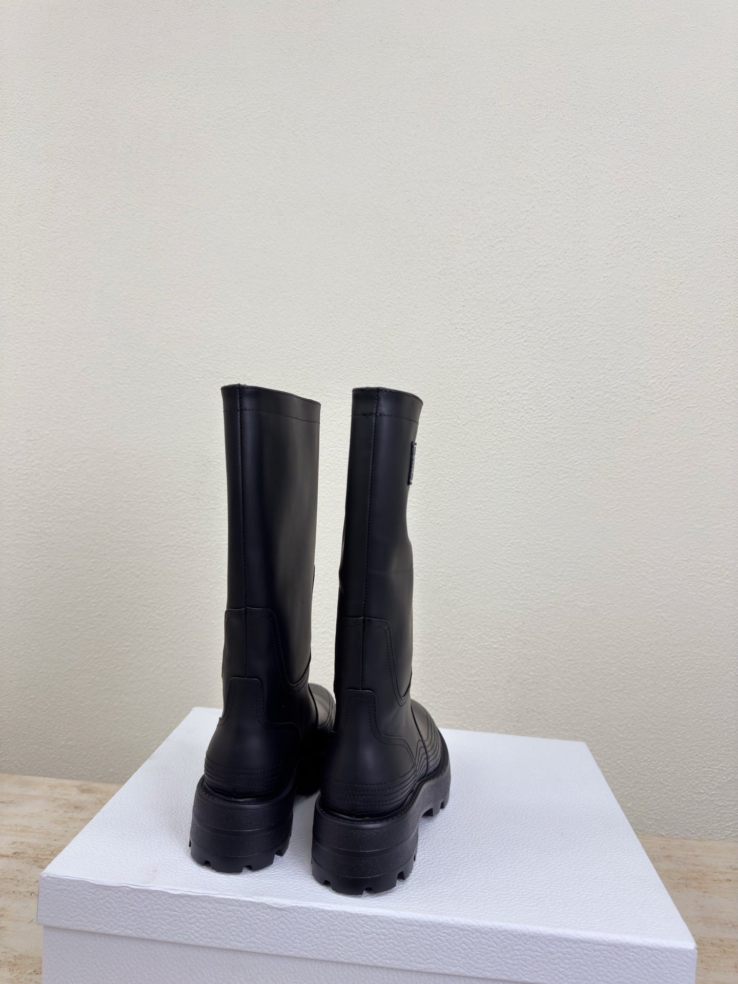 Women's dark knee-high boots, back view on display box