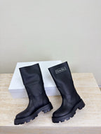 Women's dark knee-high boots, angled pair view with chunky lug soles