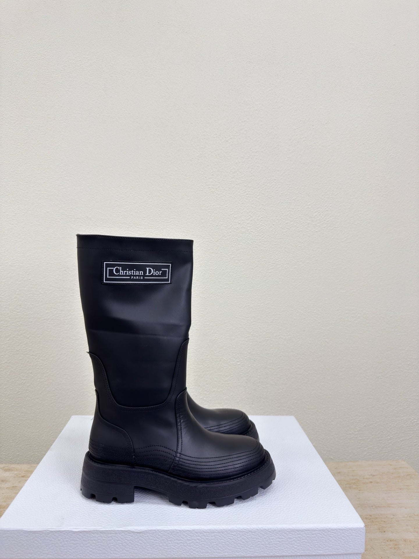 Women's dark knee-high boot with Christian Dior label and chunky lug sole