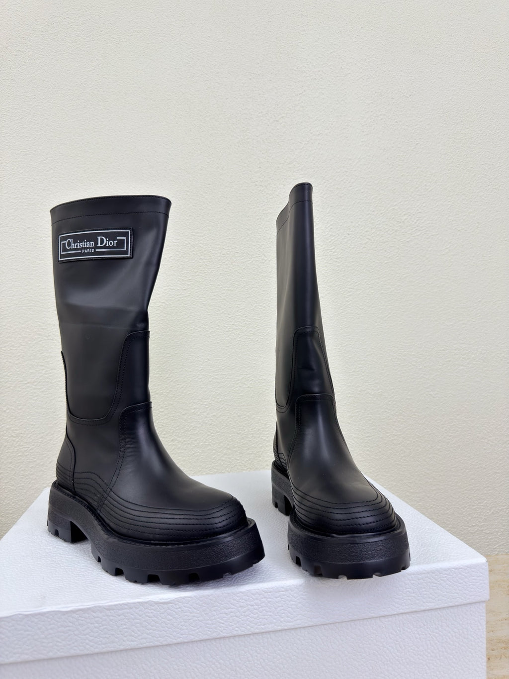 Women's dark knee-high boots, side profile pair with chunky lug soles