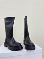 Women's dark knee-high boots, side profile pair with chunky lug soles