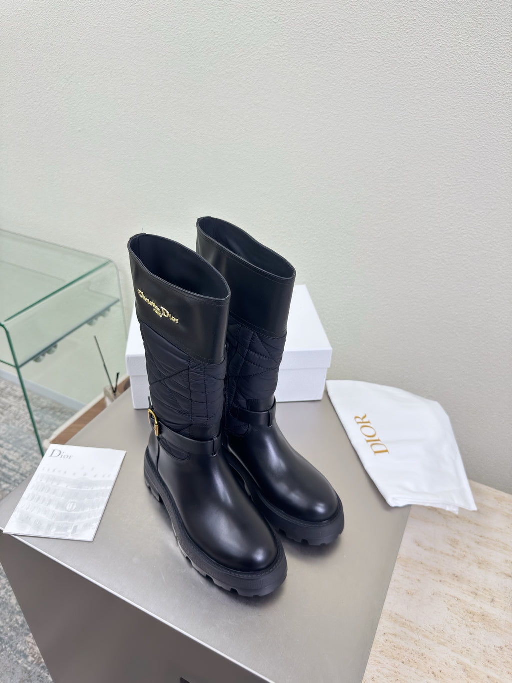 Women's black quilted leather mid-calf boots with buckle strap and lug sole