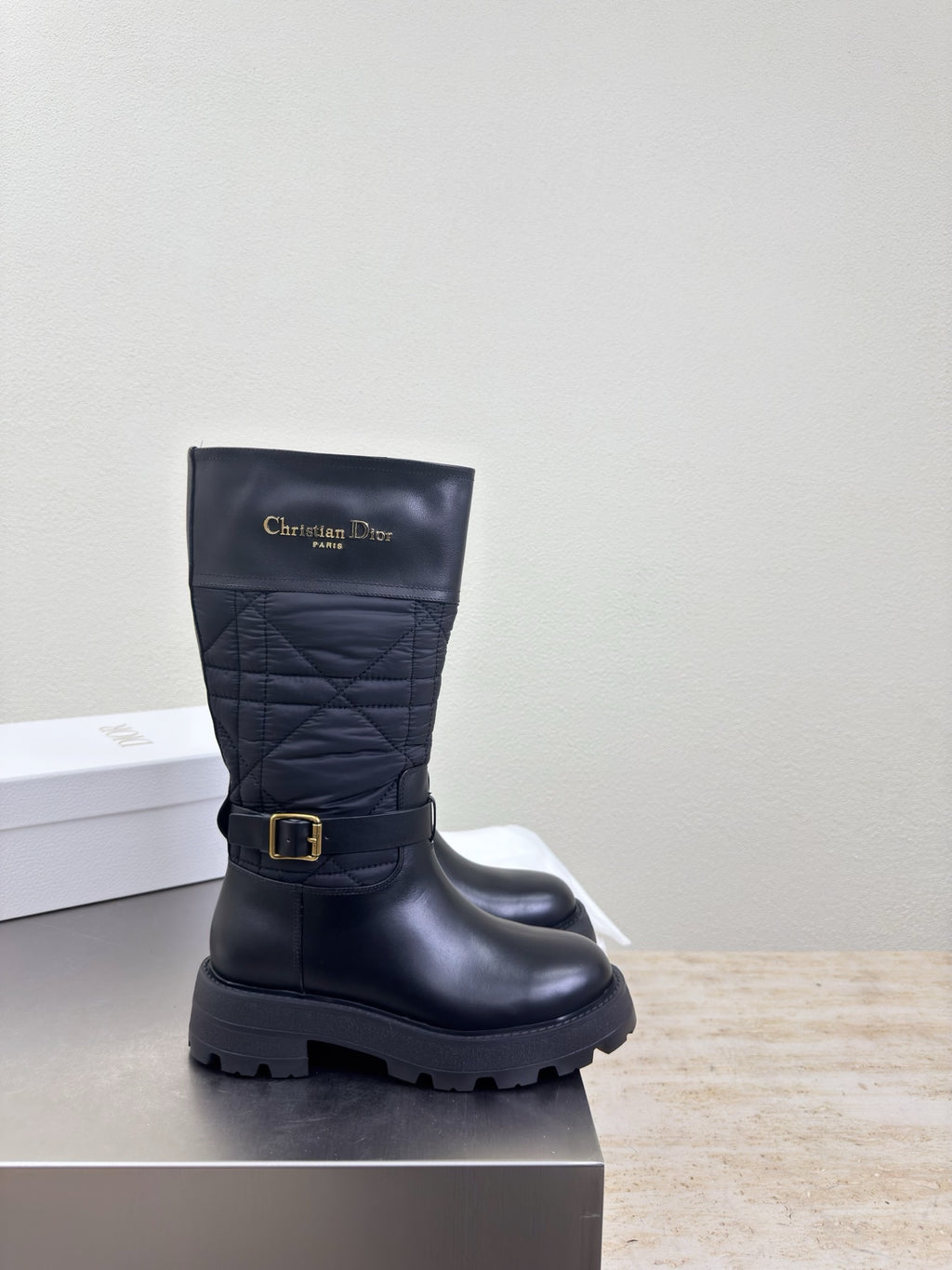 Women's black quilted mid-calf boots with buckle belt and thick tread sole