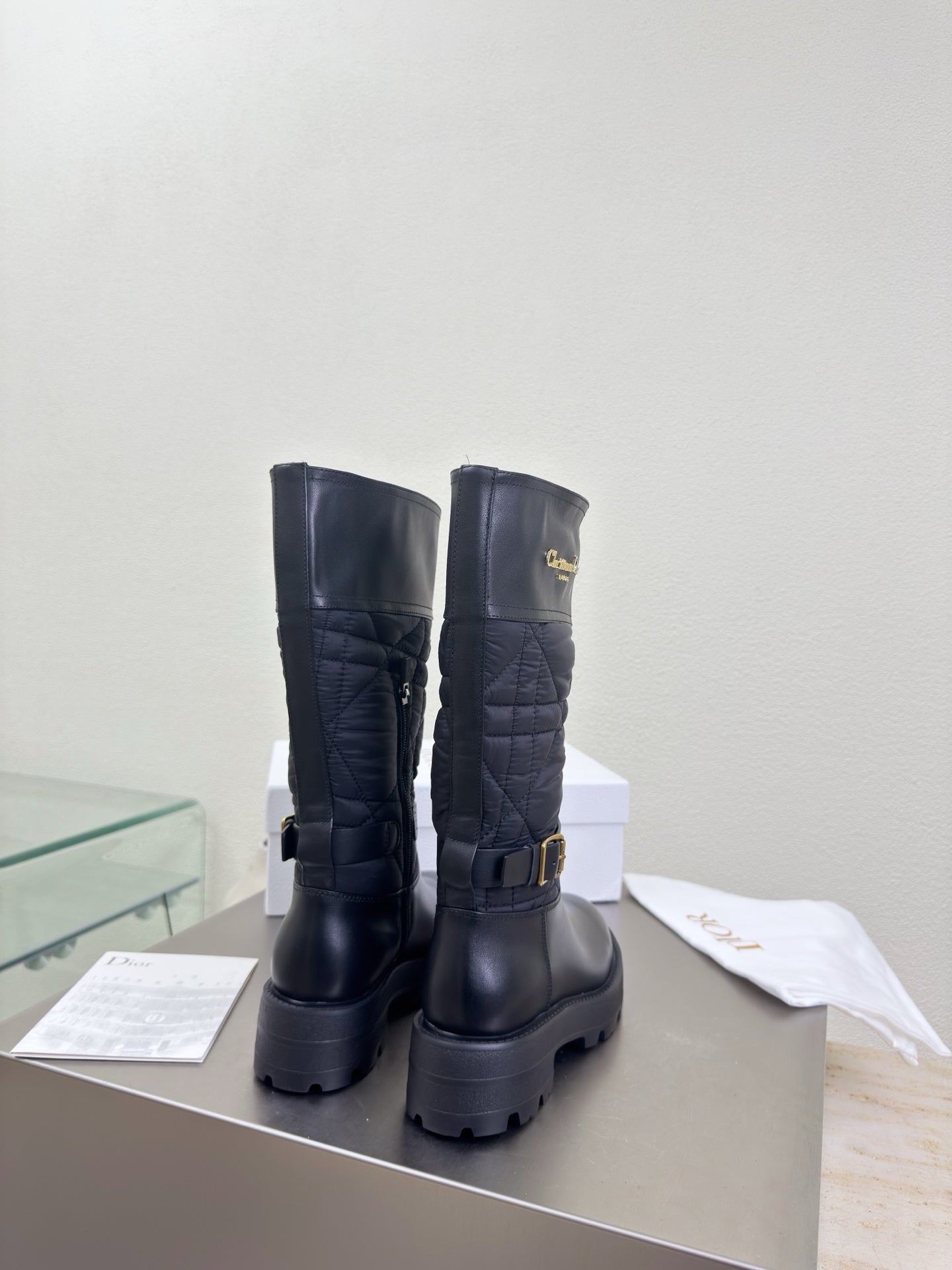 Women's black quilted mid-calf boots with buckle strap and chunky lug soles