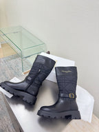 Women's black leather mid-calf boots with quilted panels, buckle, and lug sole