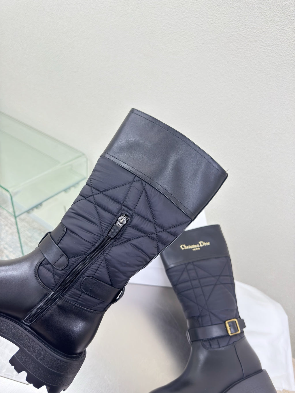 Women's black quilted mid-calf boots with adjustable buckle strap and side logo