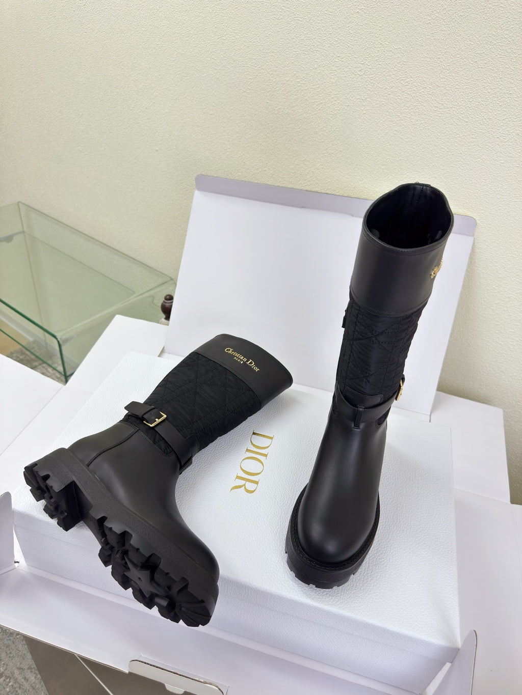 Women's Dior knee-high boots, side view, dark quilted shaft and buckle strap