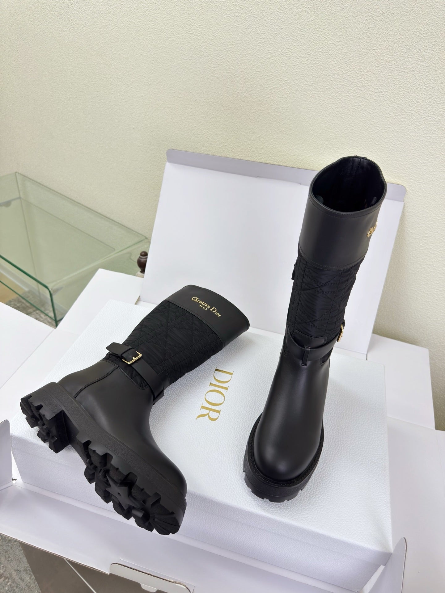 Women's Dior knee-high boots, side view, dark quilted shaft and buckle strap