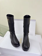Pair of women's Dior knee-high boots in dark black with textured shaft and flat sole