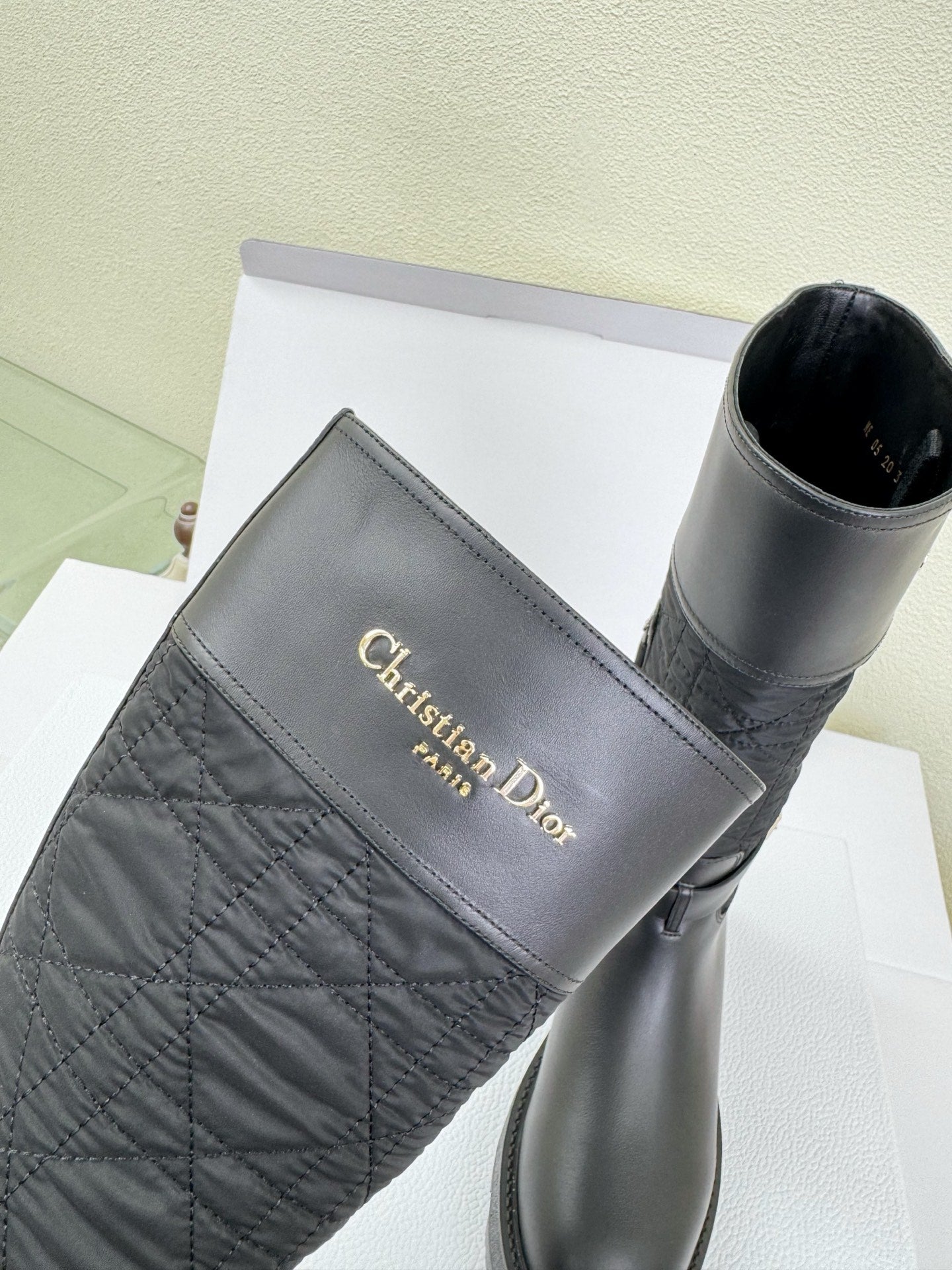Women's Dior knee-high boot with quilted upper panel and gold Dior logo
