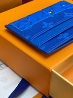 Louis Vuitton small bag, blue monogram leather front on orange box
