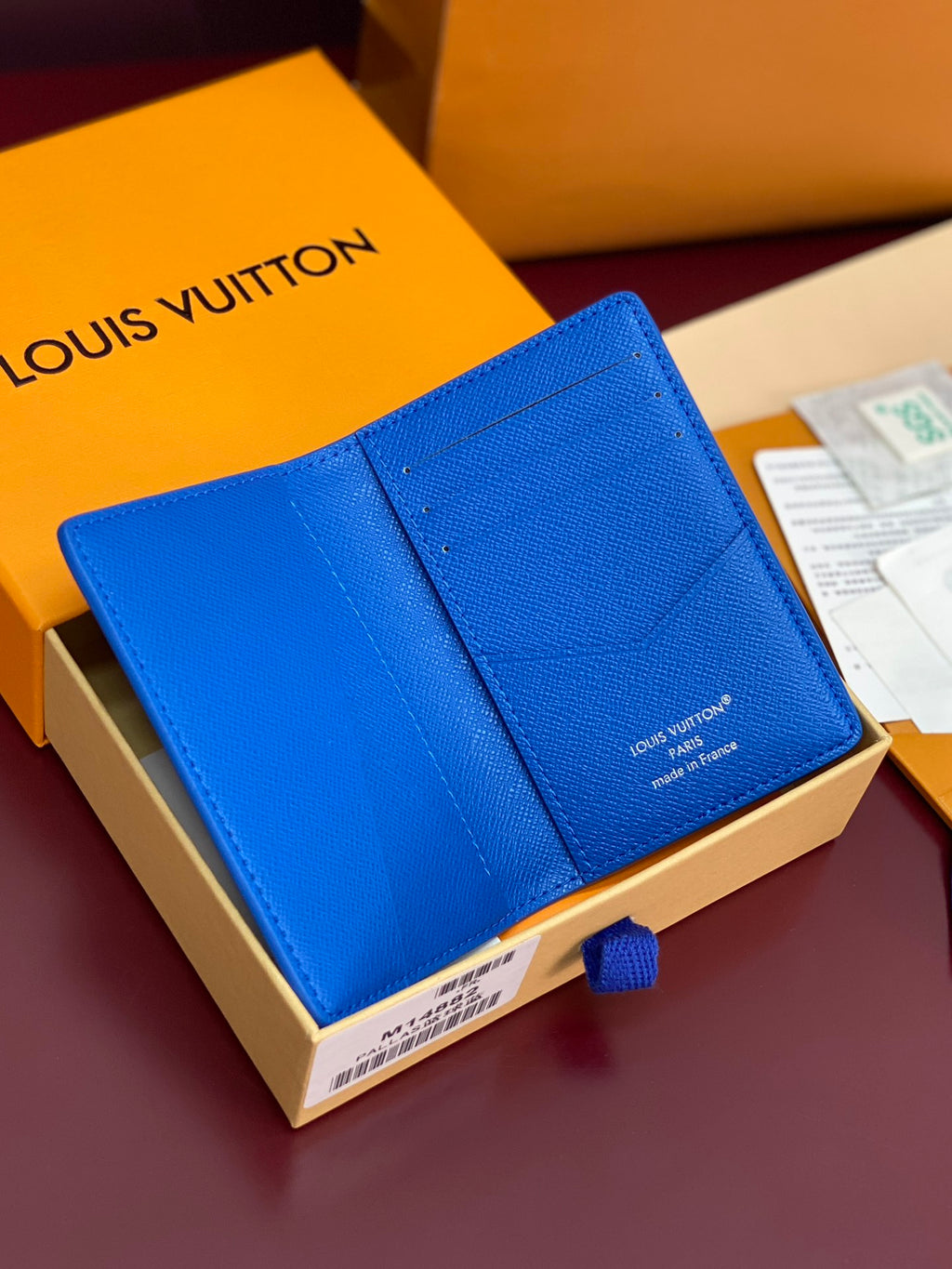 Blue small bag with foldover flap and Louis Vuitton branding on the center