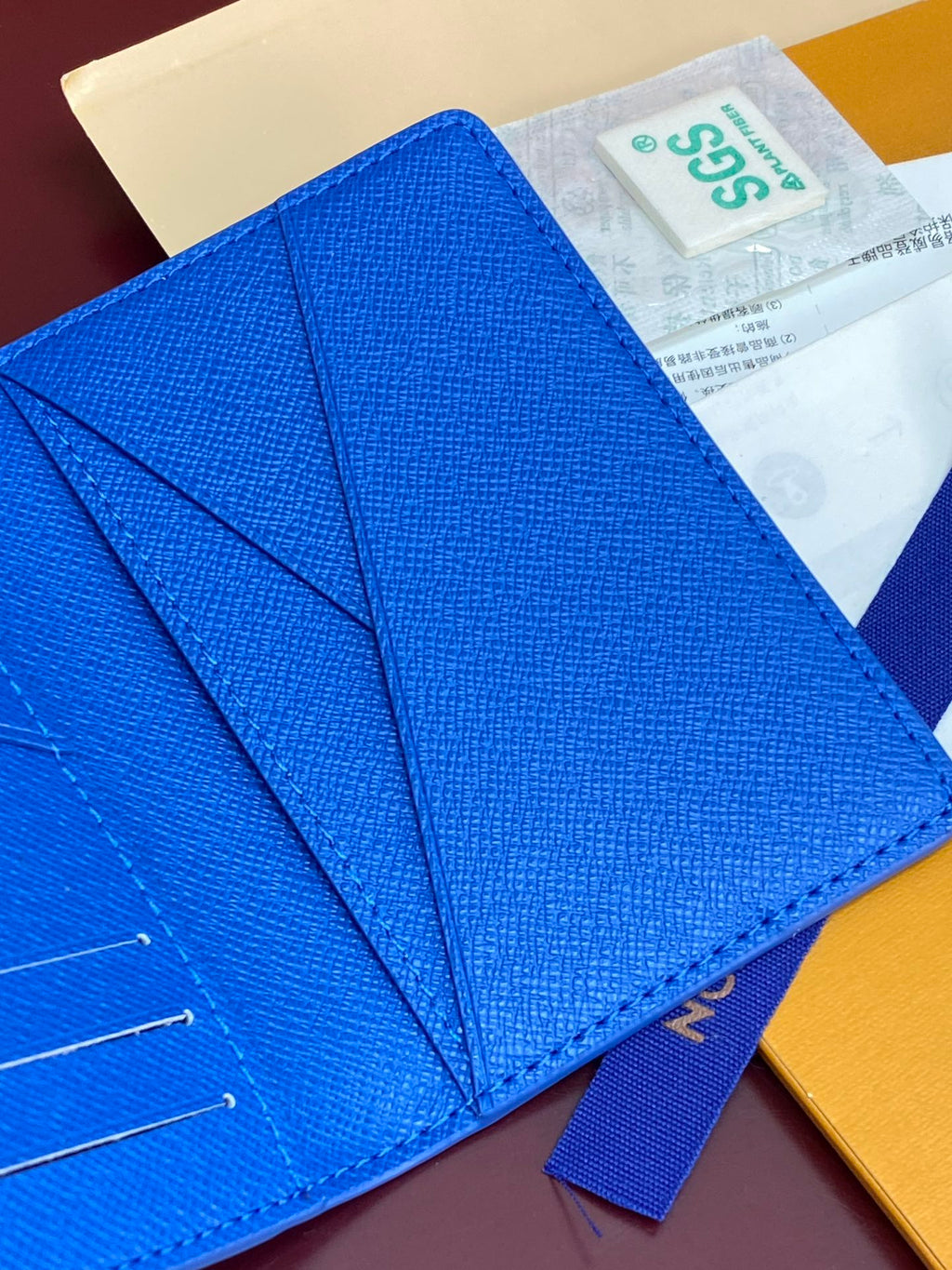 Blue small bag close-up of flap folds and stitched leather texture