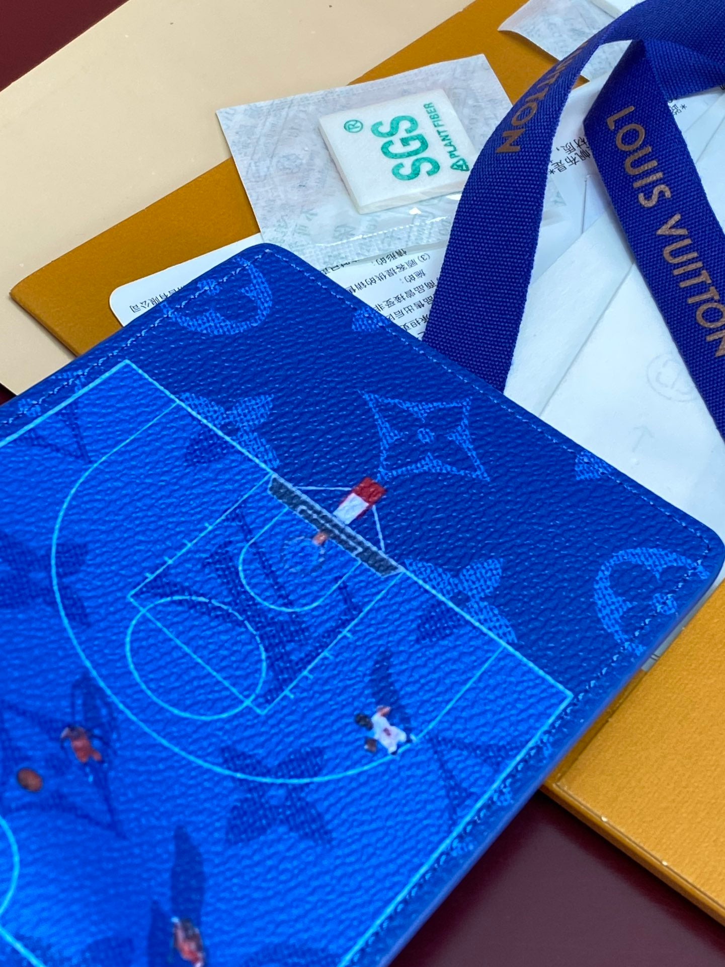 Blue Louis Vuitton small wallet close-up with constellation monogram print