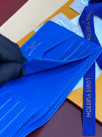 Blue Louis Vuitton small wallet close-up with stitched card pocket and strap