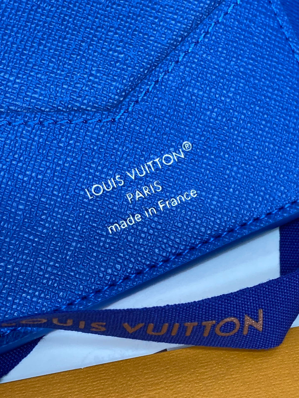 Blue Louis Vuitton small bag close-up of “made in France” text and stitching