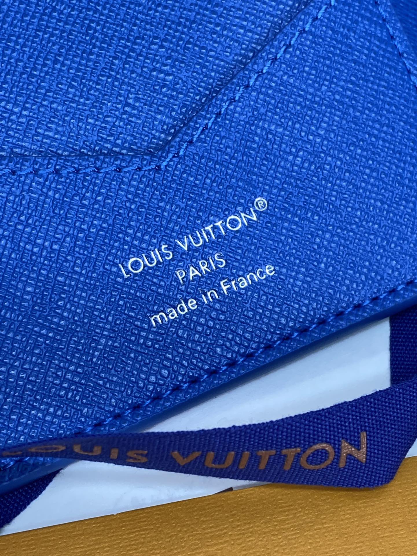 Blue Louis Vuitton small bag close-up of “made in France” text and stitching