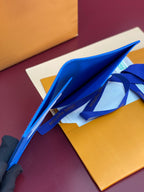 Blue small bag opened with flap and ribbon tie, inside visible