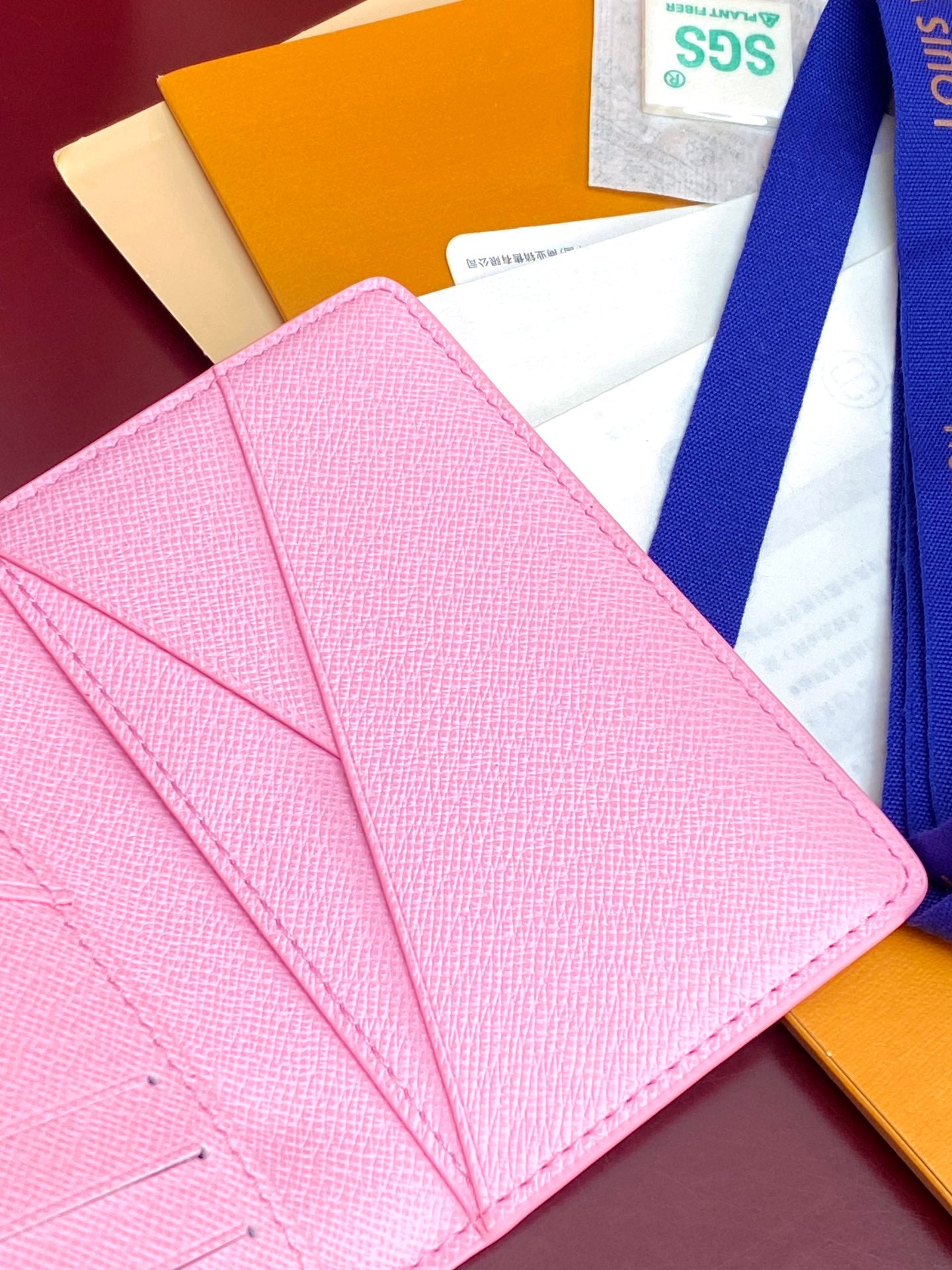 Pink Louis Vuitton small bag open with interior card slots.