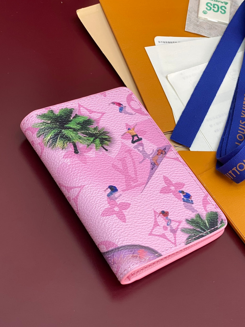 Pink Louis Vuitton small bag with tropical print and curved edge.