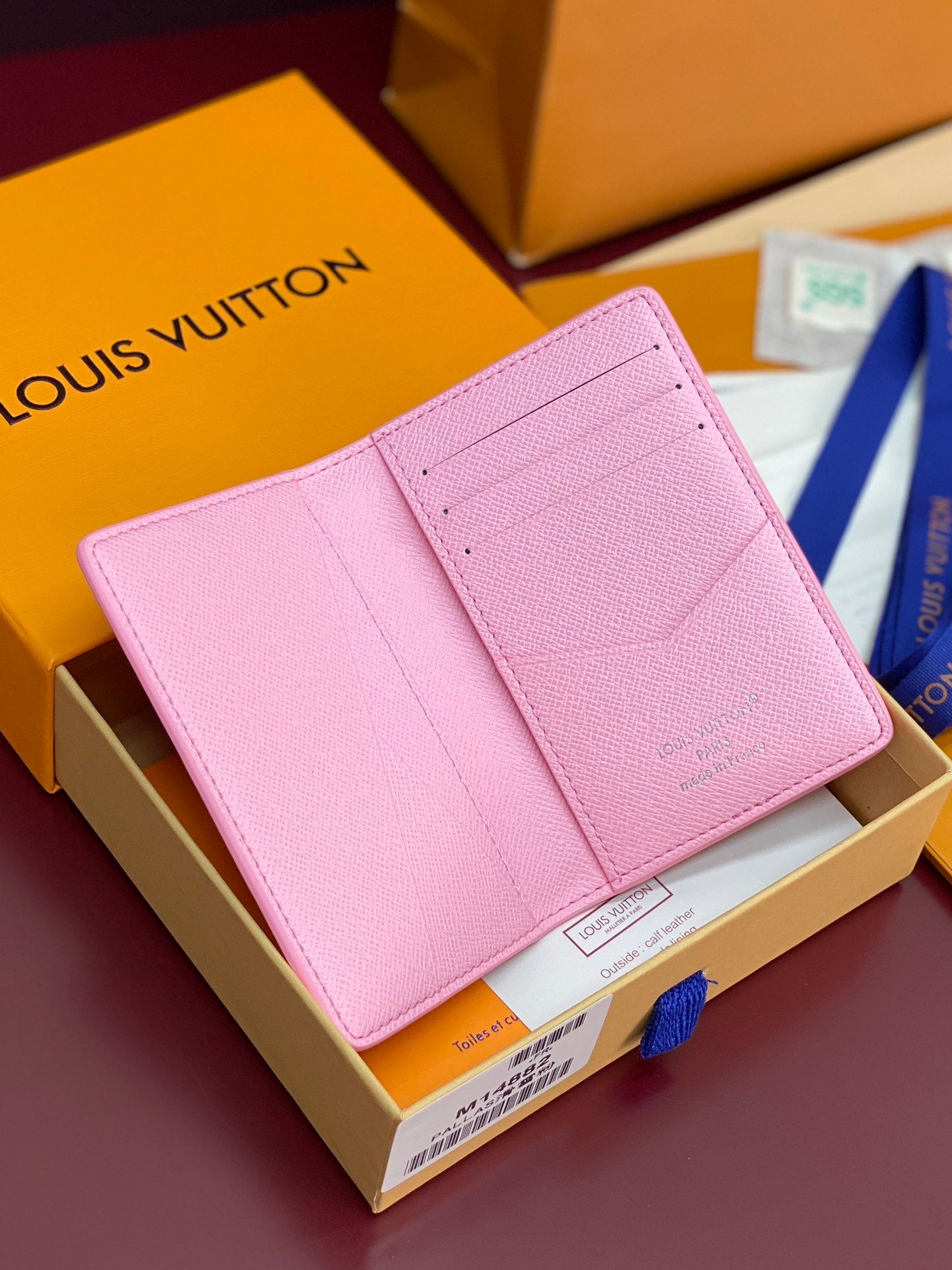 Pink Louis Vuitton small bag with textured leather and fold-over flap.